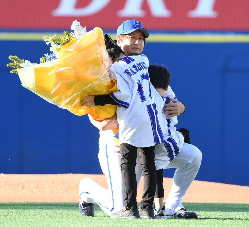 ２人の息子さんから花束を渡され、涙ぐむ前三嶋氏（撮影・佐藤厚）