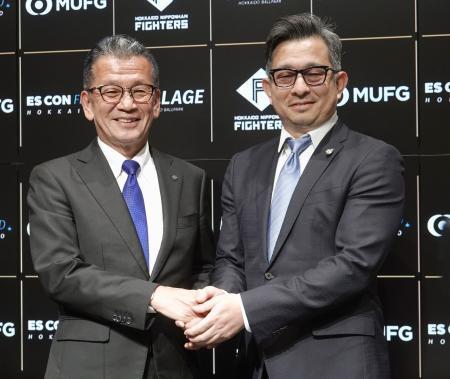 　就任の記者会見後写真撮影に応じる、エスコンフィールド北海道運営会社の前沢賢新社長（右）と小村勝前社長＝１６日、エスコンフィールド北海道