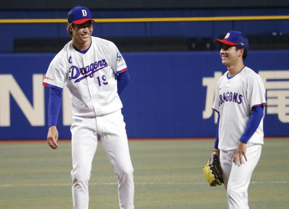 　練習中に笑顔の高橋宏（左）と金丸