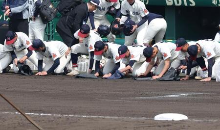 滋賀学園に敗れ、砂を集める長崎西ナイン（撮影・中田匡峻）