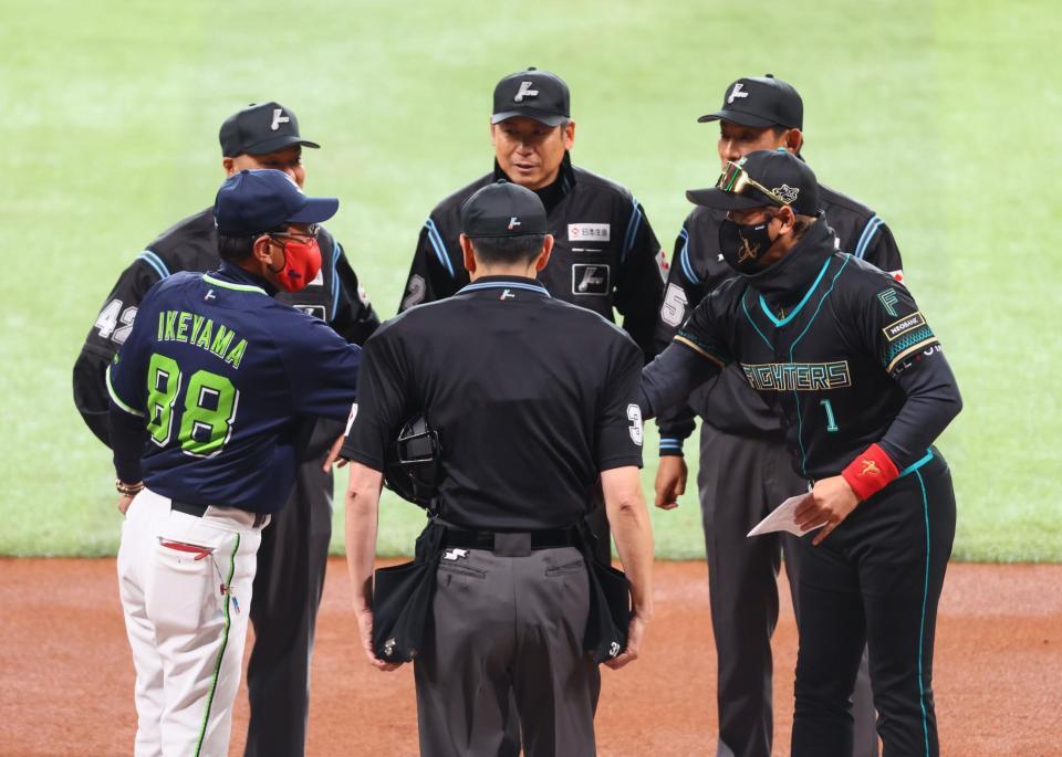 メンバー表を交換し、池山監督（左）と握手を交わす新庄監督（右）＝撮影・中島達哉