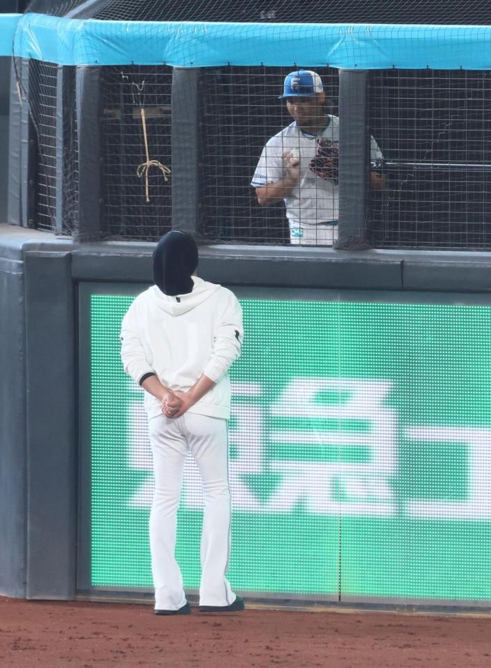 試合前、ブルペンで投球する伊藤（右）に声を掛ける新庄監督（撮影・中島達哉）