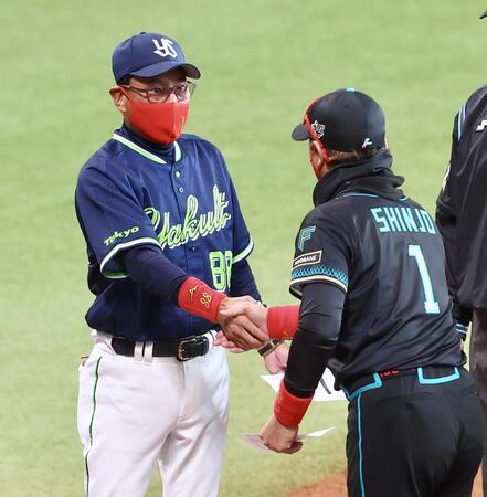 新庄監督（右）からプレゼントされた赤いマスクをしてメンバー表を交換し握手を交わす池山監督（撮影・中島達哉）