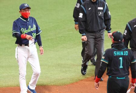 　メンバー交換で新庄監督（１）が同じ赤いマスクをしてきたことに笑顔を見せる池山監督（撮影・中島達哉）