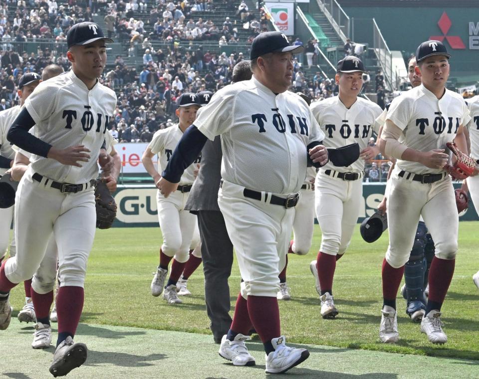 スタンドへのあいさつを終えて、引き揚げる大阪桐蔭・西谷監督（中央）ら