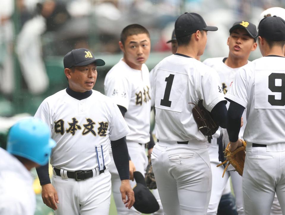 １回の守備を終え、ナインに声をかける日本文理・鈴木崇監督（左）＝撮影・西田忠信