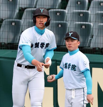 試合前、シートノックを手伝う山梨学院・菰田陽生（左）＝撮影・山口登