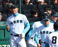 ５回表を終え、ベンチでナインを迎える山梨学院・菰田（左）