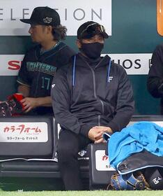 　６回、戦況を見つめる新庄監督（左はベンチ裏に引き揚げる伊藤）＝撮影・中島達哉
