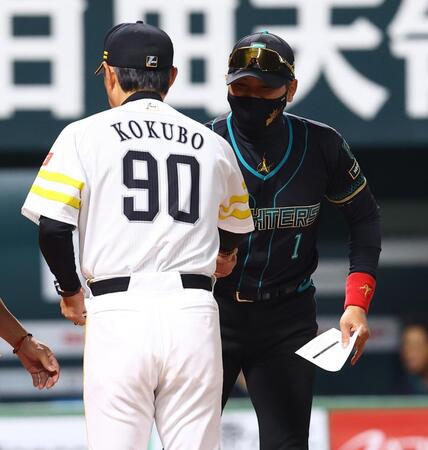 メンバー表を交換し、小久保監督（左）と握手を交わす新庄監督（撮影・中島達哉）