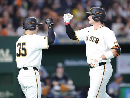 ５回、泉口（左）とタッチを交わすダルベック（撮影・西岡正）