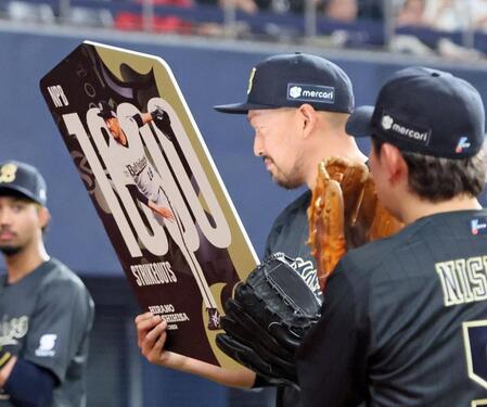 １０００奪三振を達成し記念ボードを掲げる平野（撮影・立川洋一郎）