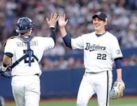 　完封勝利を飾り若月（左）とタッチを交わす九里（撮影・立川洋一郎）