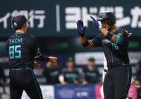 ２回、同点ソロを放ち、谷内内野守備走塁コーチ（左）に迎えられる万波（撮影・中島達哉）