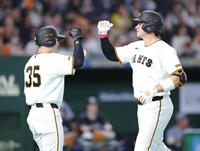 ５回、泉口（左）とタッチを交わすダルベック（撮影・西岡正）