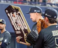 １０００奪三振を達成し記念ボードを掲げる平野（撮影・立川洋一郎）