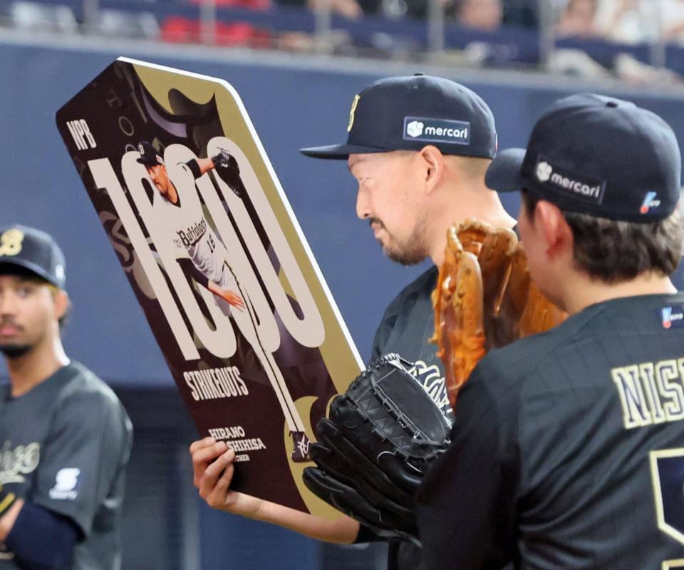 １０００奪三振を達成し記念ボードを掲げる平野（撮影・立川洋一郎）