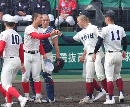 両チームのあいさつを終え互いの健闘をたたえ合いタッチを交わす智弁学園・杉本真滉（左から２人目）＝撮影・立川洋一郎