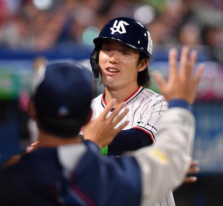 ８回、丸山の左前適時打で生還しナインとタッチを交わす長岡（撮影・開出牧）