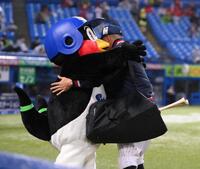 試合前、オスナ（右）と抱き合うつば九郎（撮影・開出牧）