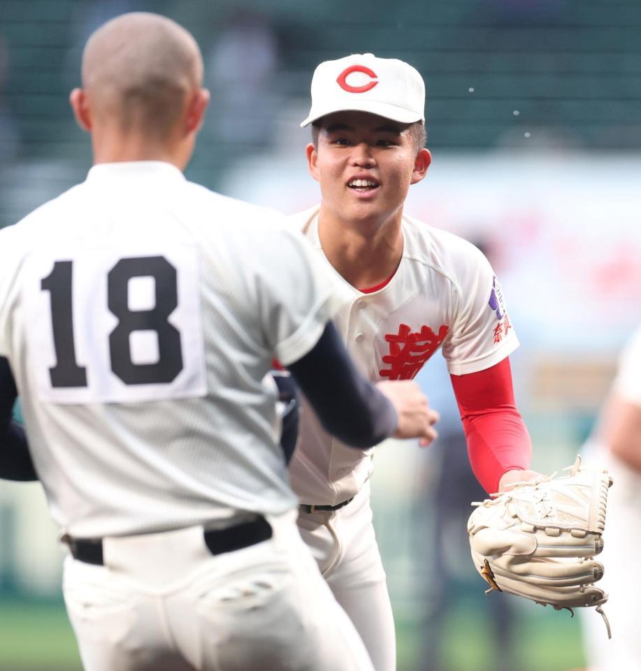 １回を投げ終え、ベンチに戻る際バットを大阪桐蔭・小泉凛太郎（左）に渡す智弁学園・杉本真滉（撮影・中田匡峻）