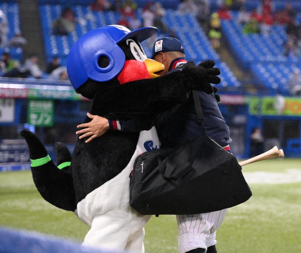 試合前、オスナ（右）と抱き合うつば九郎（撮影・開出牧）