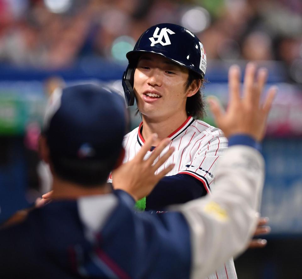 ８回、丸山の左前適時打で生還しナインとタッチを交わす長岡（撮影・開出牧）