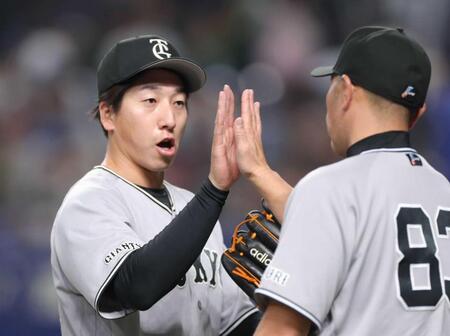 　最後を締め、阿部監督（右）とタッチを交わす大勢（撮影・西岡正）