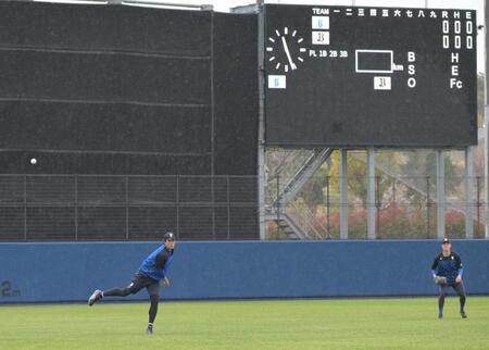 雨の中投球練習する藤浪（左）＝撮影・金居みつよし