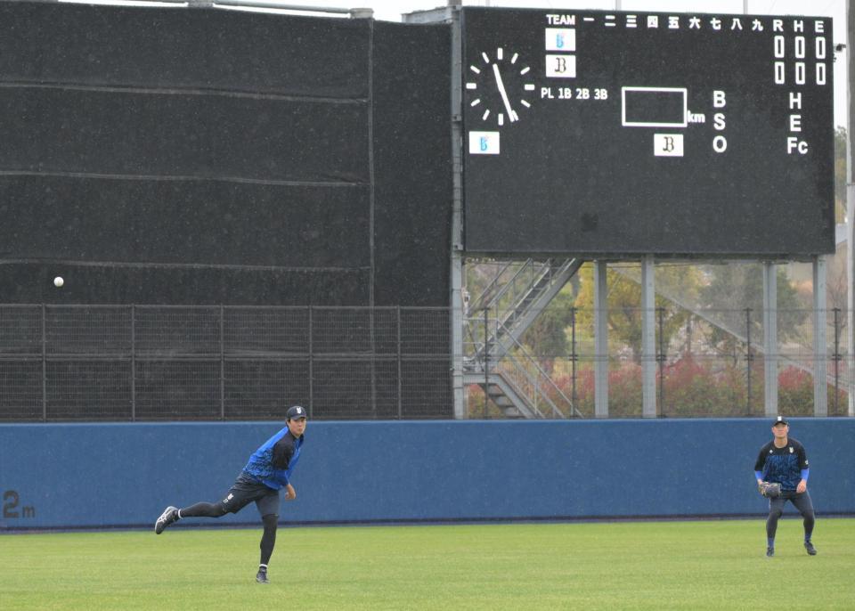 雨の中投球練習する藤浪（左）＝撮影・金居みつよし