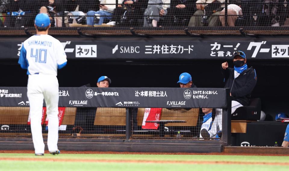 ７回、西川を遊ゴロに抑えた島本（左）を指さす新庄監督（撮影・中島達哉）