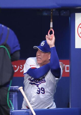 ベンチのつり革でストレッチする井上監督（撮影・西岡正）