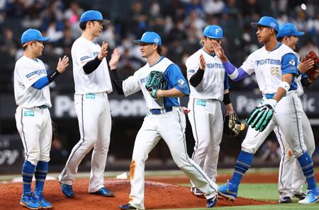 ロッテに勝利をあげ、タッチを交わす西川（中央）ら日本ハムナイン（撮影・中島達哉）