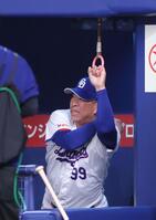 ベンチのつり革でストレッチする井上監督（撮影・西岡正）