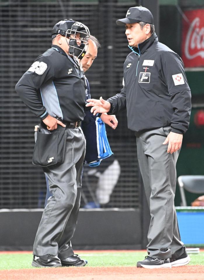 ４回途中治療に向かう深谷球審（左）＝３日