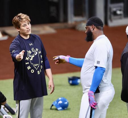 試合前、日本ハムのレイエス（右）と言葉を交わす九里（撮影・中島達哉）