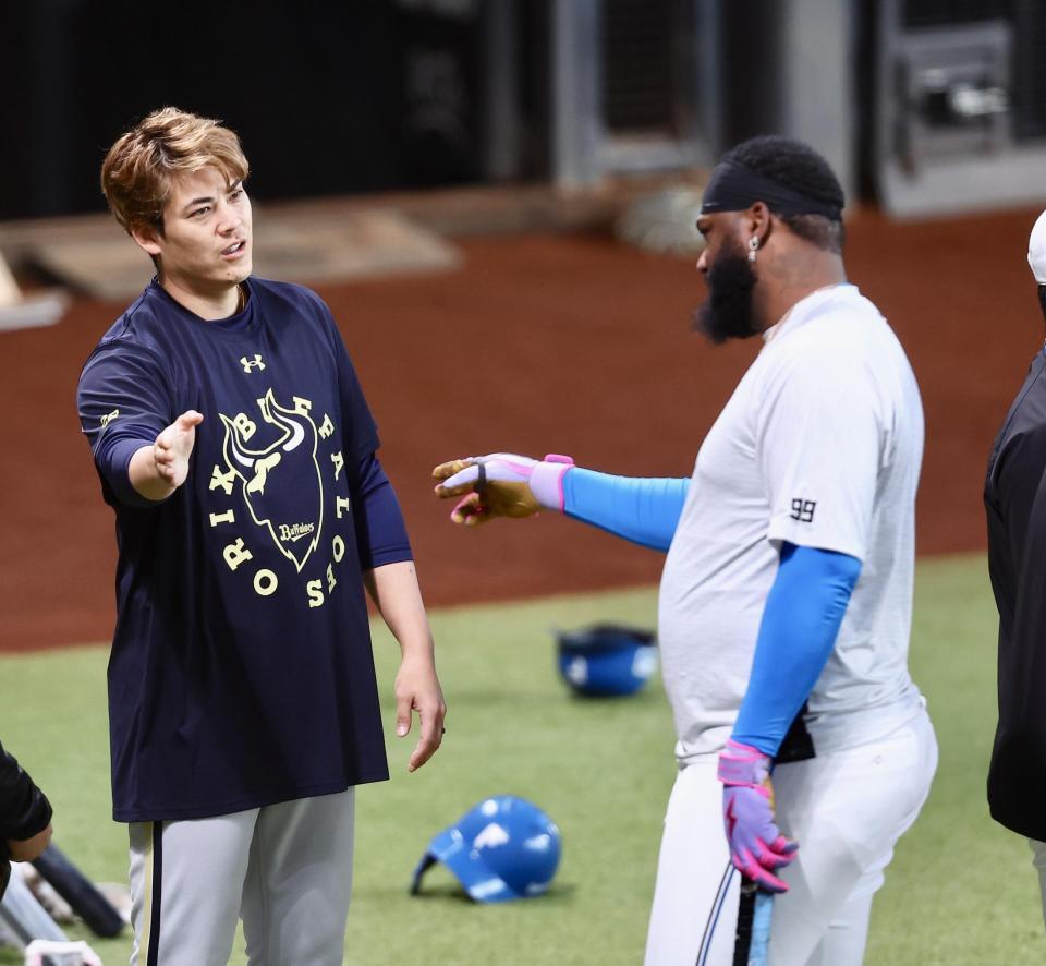 試合前、日本ハムのレイエス（右）と言葉を交わす九里（撮影・中島達哉）