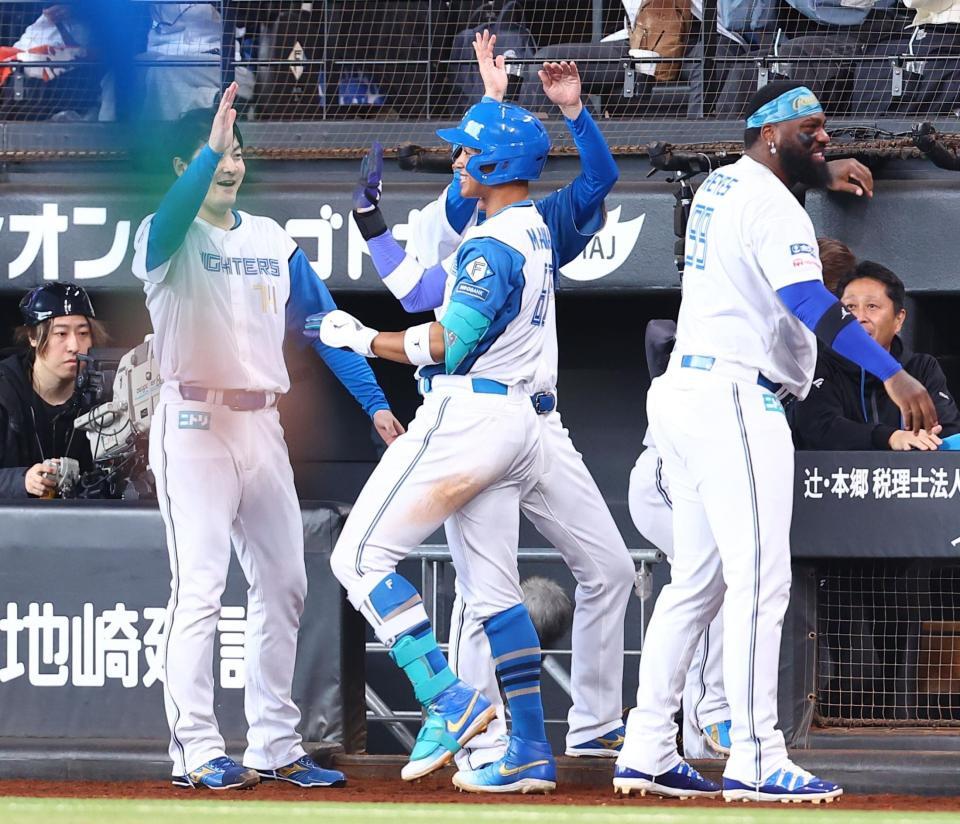 ７回、勝ち越し３ランを放った万波（中央）を迎える有原（左）ら日本ハムナイン（撮影・中島達哉）