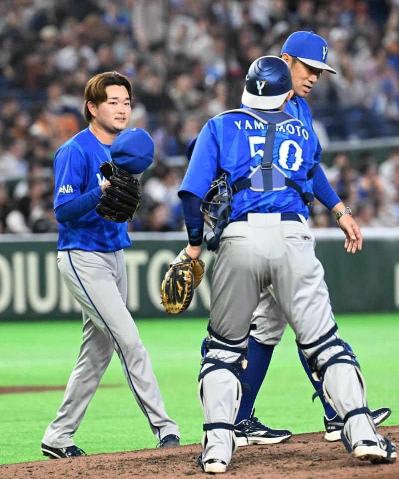 ７回裏、投手交代でマウンドを降りる石田裕（左）。右奥は相川監督