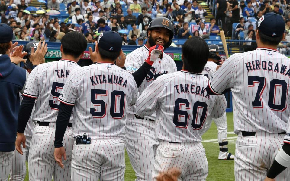 ７回、勝ち越しの中越え２点本塁打を放ちナインに迎えられるサンタナ（撮影・持木克友）