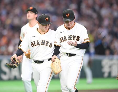 ４回、バランスを崩して転げながら投球した竹丸（右）。スタートを切った二塁手のオスナを三塁タッチアウトにしピンチを脱し、不思議そうに左手を見つめる。左は遊撃手の泉口（撮影・開出牧）