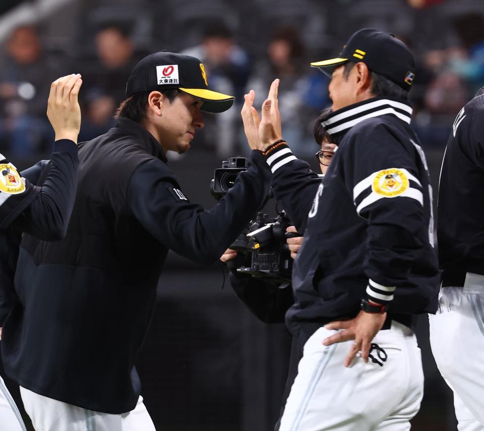 小久保監督（右）に迎えられる上沢（撮影・中島達哉）