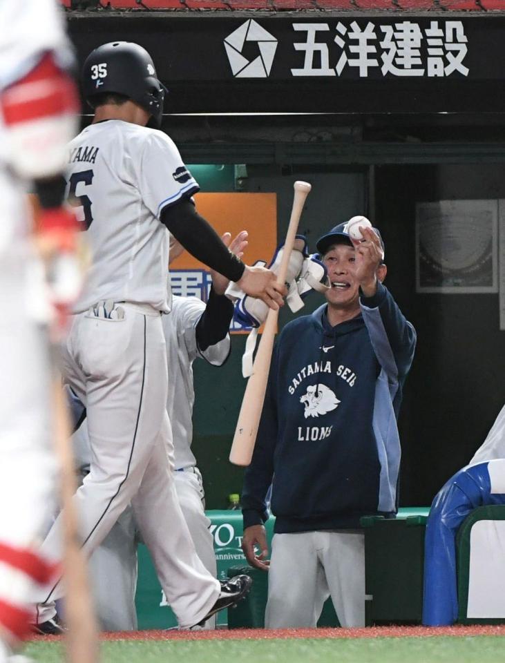 秋山（左）にプロ初安打の記念球を手渡す西口監督（撮影・佐藤厚）