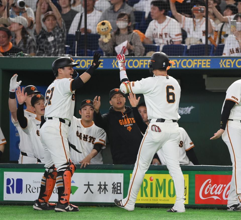 ７回、中越えソロを放ち山瀬（左）らナインとタッチを交わす坂本（６）＝撮影・開出牧