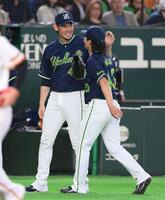 ８回、佐々木を見逃し三振に仕留めた増居（右）と笑顔でタッチを交わす高梨（撮影・開出牧）