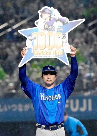 　記念ボードを掲げる佐野