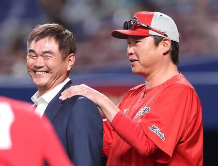 練習中に岩瀬仁紀氏の肩をもむ新井監督（右）＝撮影・北村雅宏