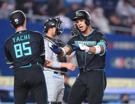 ５回、右越えソロを放ち谷内コーチ（左）とタッチを交わす万波。捕手・佐藤（撮影・開出牧）