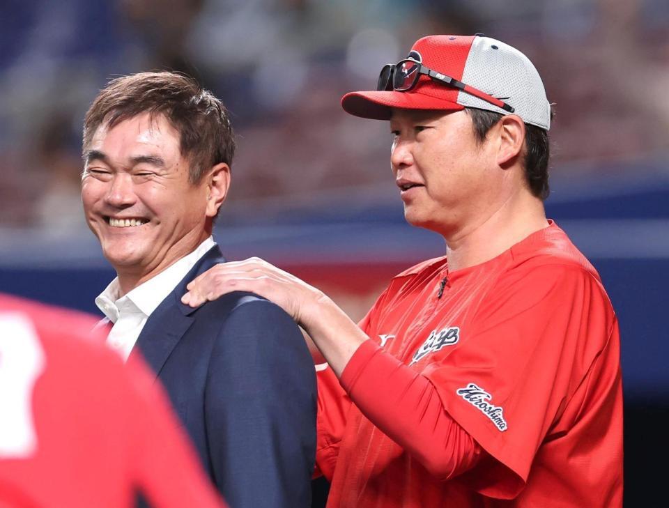 練習中に岩瀬仁紀氏の肩をもむ新井監督（右）＝撮影・北村雅宏