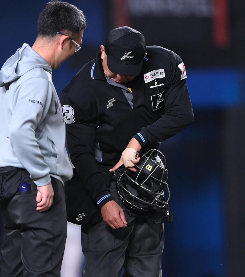 折れたバットが直撃した右腕を指差す深谷篤球審（撮影・開出牧）